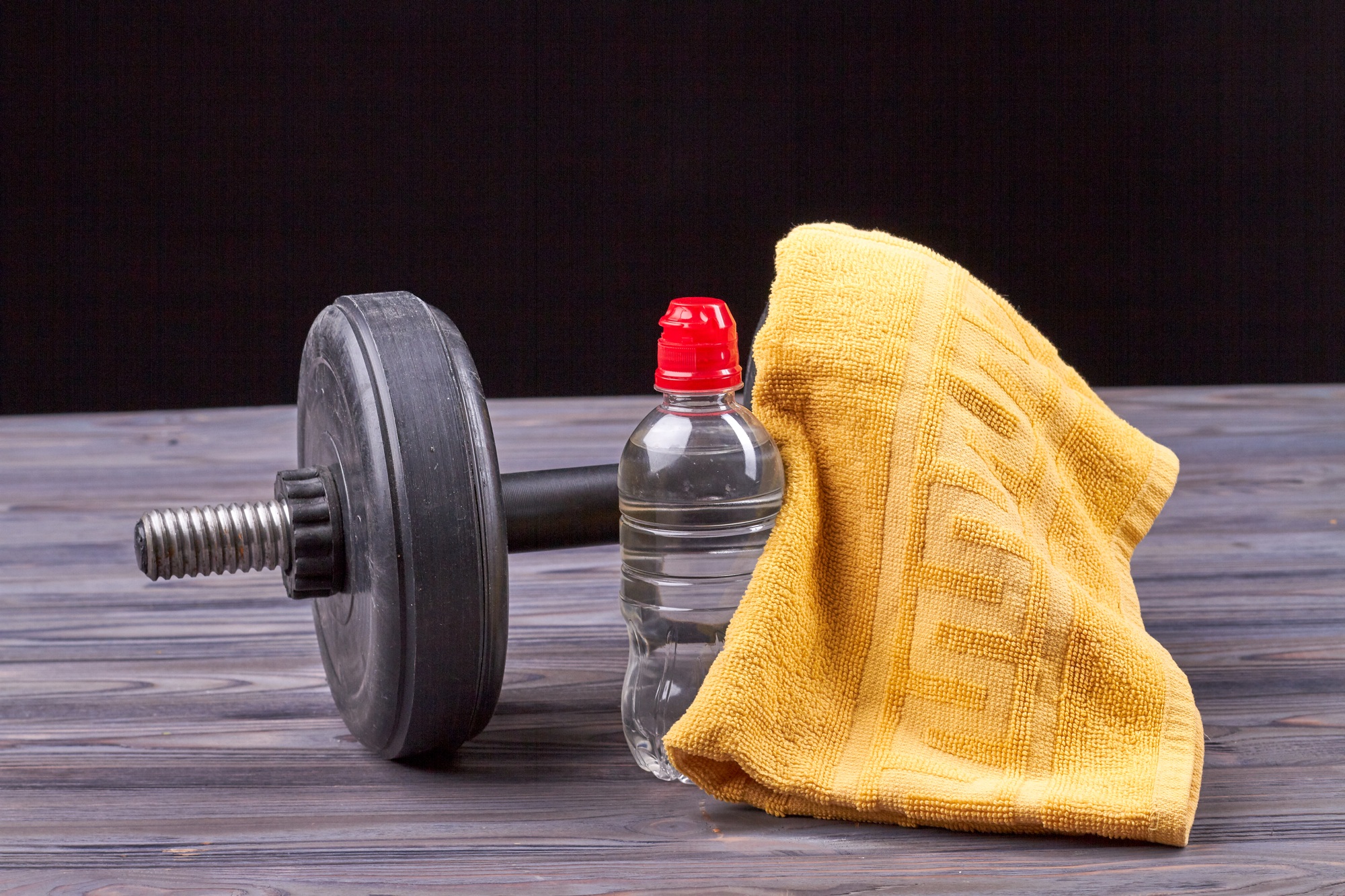 Bottle of water with dumbbell and towel